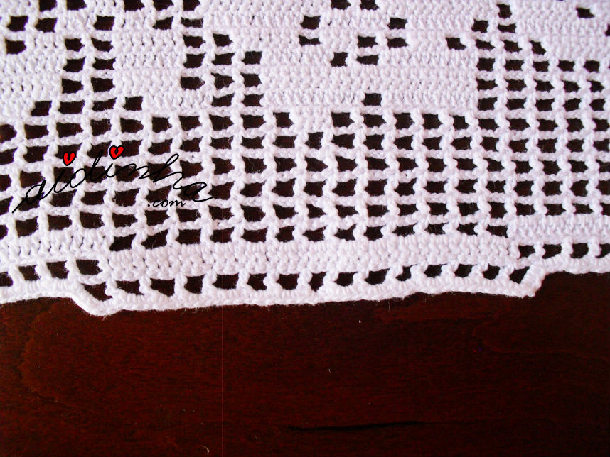 Pormenor do caseado de lado do naperon de crochet, com rosa