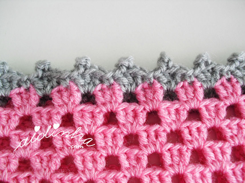 Foto da volta de acabamento do poncho de crochet, rosa e cinza