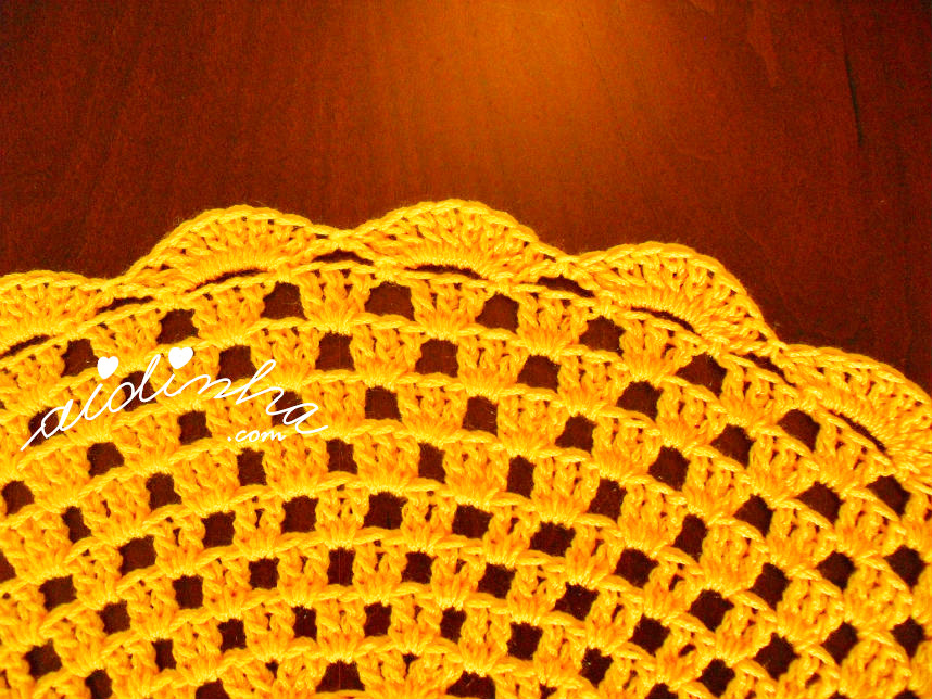 Foto da última volta do individual amarelo de crochet