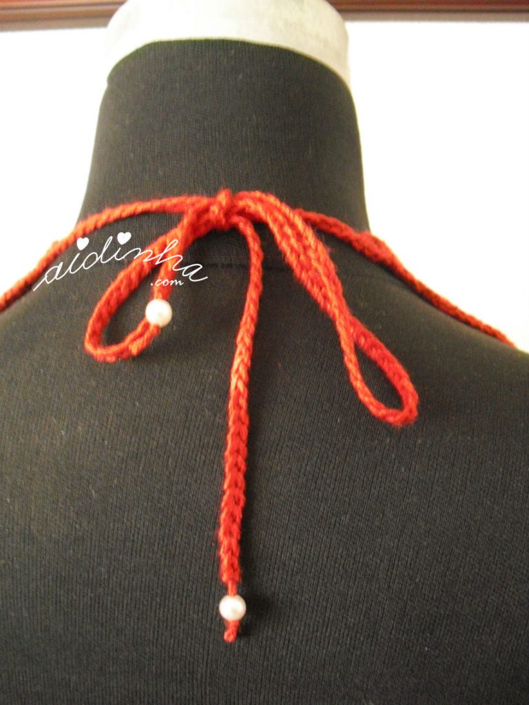 Parte detrás do colar de crochet, vermelho com pérolas