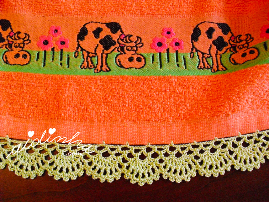 Pormenor do crochet do pano de cozinha laranja com vaquinhas
