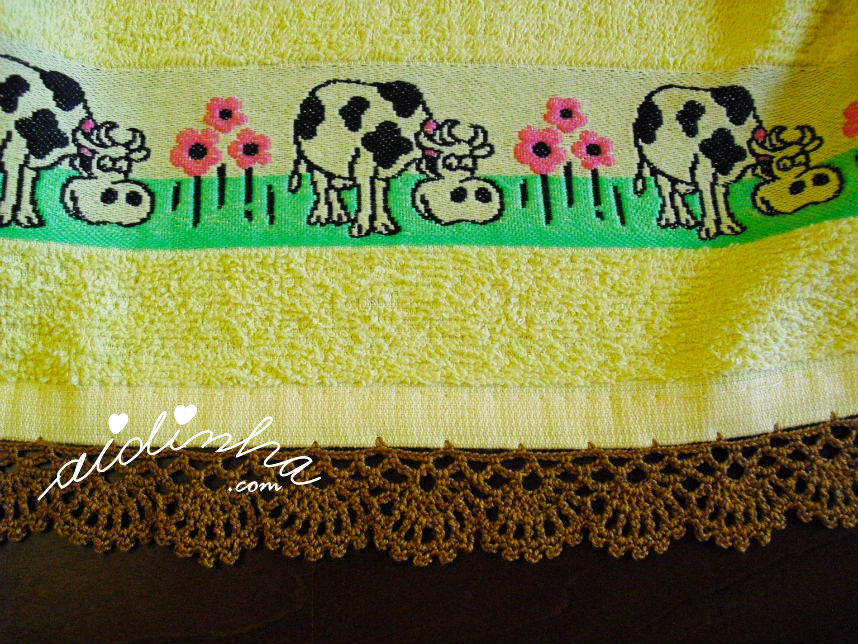 Pormenor do crochet do pano de cozinha amarelo com vaquinhas e crochet