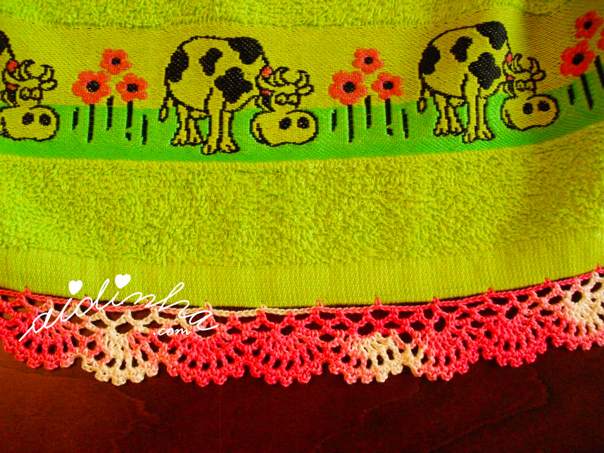 Pormenor do crochet do pano de cozinha verde, com vaquinhas e crochet