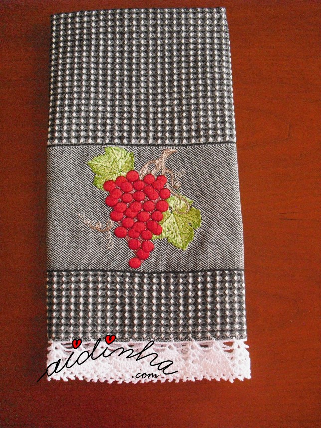 outra foto do pano com uvas vermelhas e crochet branco