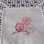 Centro em linho, com florinhas bordadas à mão e crochet