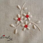 Centro em linho, bordado à mão, com bainha aberta e crochet em vermelho